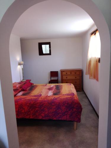 - une chambre avec un lit doté d'un couvre-lit rouge dans l'établissement A 5 minutes d ' ANNECY T2 dans maison champêtre au calme, à Villaz
