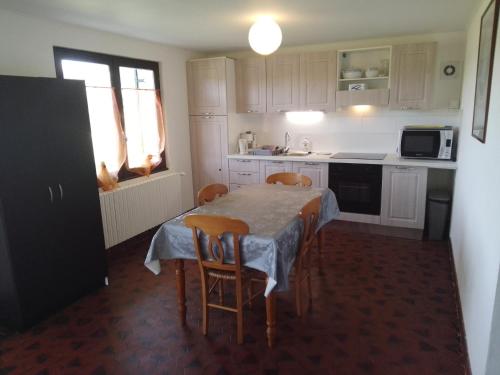 une cuisine avec une table et des chaises et une cuisine avec des armoires blanches dans l'établissement A 5 minutes d ' ANNECY T2 dans maison champêtre au calme, à Villaz