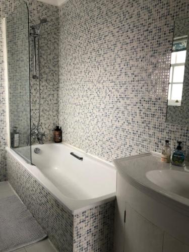 a white bathroom with a tub and a sink at Kingfisher House - Sandwich in Sandwich