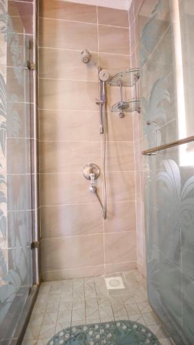 a shower with a glass door in a bathroom at Tamasha Luxury Villa - Diani in Diani Beach