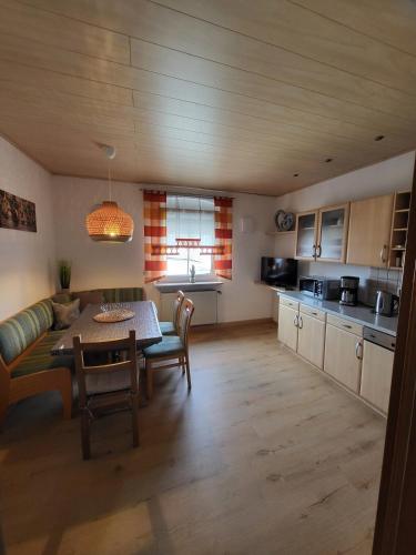 a kitchen and living room with a table and a couch at Haus Lehneis in Teublitz