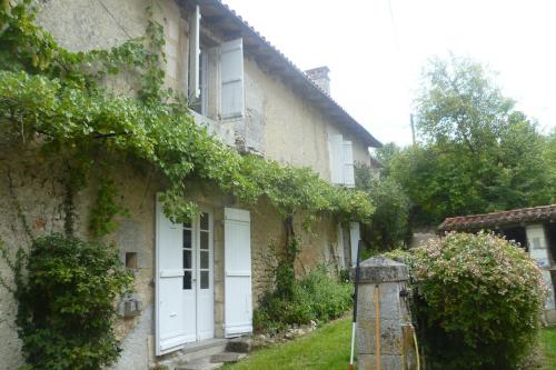 une vieille maison avec du lierre sur son côté dans l'établissement Dordogne Larmalie, à Allemans