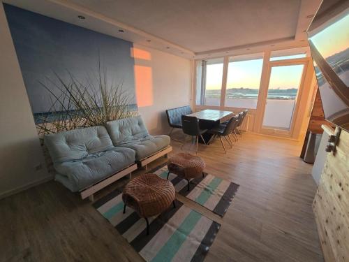 a living room with a couch and a table at Moderne Wohnung mit Sonnenuntergang über dem Meer in Heiligenhafen