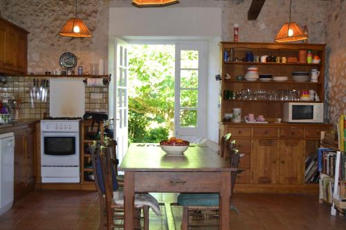 une cuisine avec une table avec un bol de fruits dessus dans l'établissement Dordogne Larmalie, à Allemans