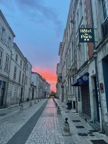an empty city street with a sunset in the background at Hotel de Paris in La Rochelle