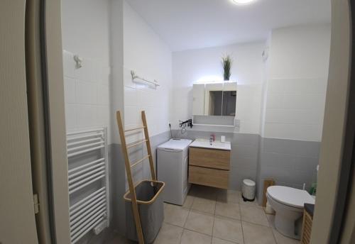 une salle de bain blanche avec un lavabo et des toilettes dans l'établissement U Sognu - Proche plage vue montagne, à LʼÎle-Rousse