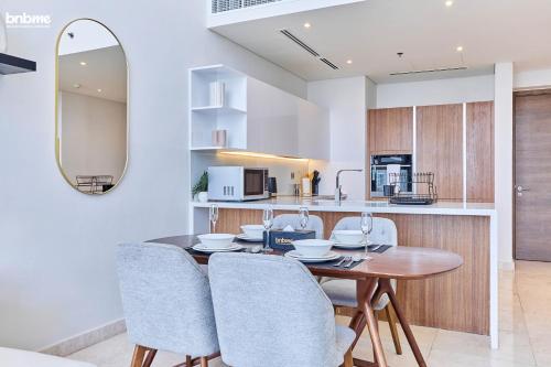 a kitchen and dining room with a table and chairs at bnbmehomes - Anwa in Dubai