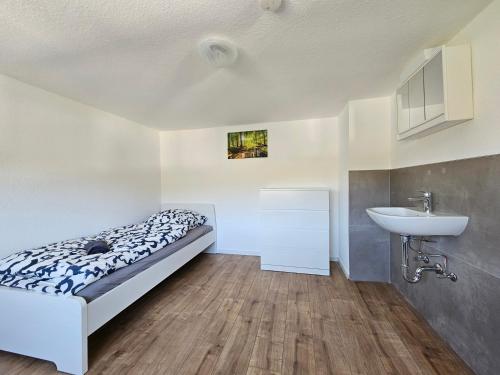 een slaapkamer met een bed en een wastafel bij SIM01 Renovierte Monteurs- und Ferienwohnung in Simmerath in Simmerath