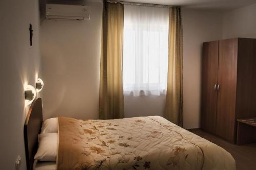 a small bedroom with a bed and a window at Domus Damar in Međugorje