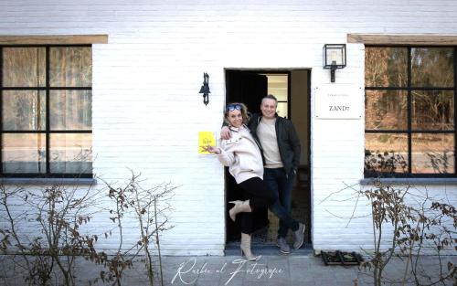 a man and a woman standing in the doorway of a house at Vakantiehuis Zand7 in Lommel