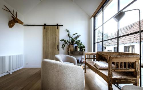 a living room with white walls and a large window at Vakantiehuis Zand7 in Lommel