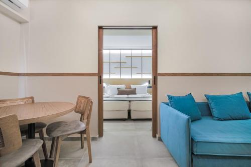 a living room with a blue couch and a table at Capsis Astoria Heraklion in Heraklio Town