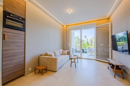 un salon avec un canapé et une télévision dans l'établissement 2 bedroom with terrace and garden view 2 min from beach, à Cannes