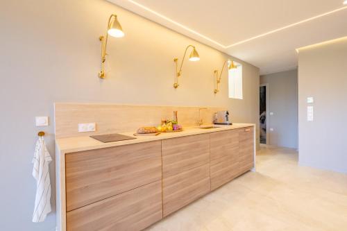 une cuisine avec des armoires en bois et un comptoir dans l'établissement 2 bedroom with terrace and garden view 2 min from beach, à Cannes