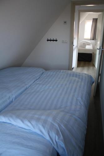 a bed in a bedroom with a sink in a room at De Wieringerheid 162 in Den Oever