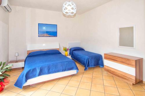 トラーパニにあるCasa Granataのベッドルーム1室(青いシーツとテーブル付きのベッド2台付)