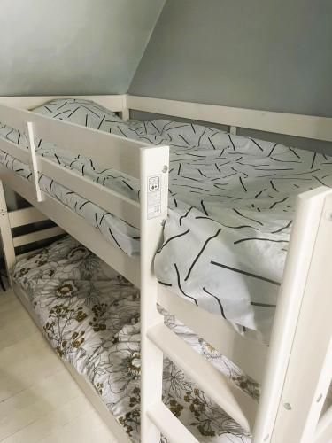 Ce lit superposé blanc se trouve dans un dortoir de 2 lits. dans l'établissement Skol Ar Louarn - Maison de vacances Ile-grande, à Pleumeur-Bodou