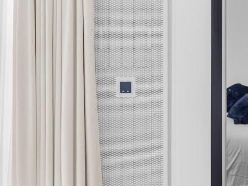 a bedroom with a white curtain next to a bed at Modern Flat in Central Cambridge in Girton