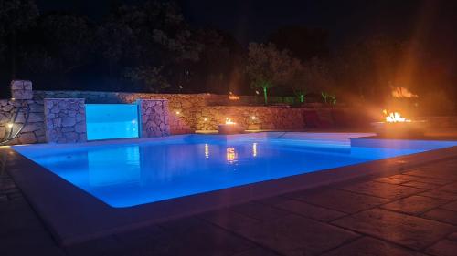a swimming pool with blue lighting at night at Villa Sunset in Mandre