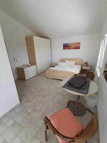 a bedroom with a bed and a table and a chair at Villa Sunset in Mandre