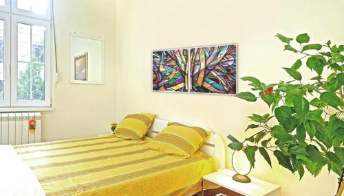 ein Schlafzimmer mit einem Bett und einer Pflanze in der Unterkunft APARTMAN KRUNA in Belgrad