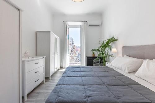 a white bedroom with a large bed and a window at SUN HOUSE in Bari