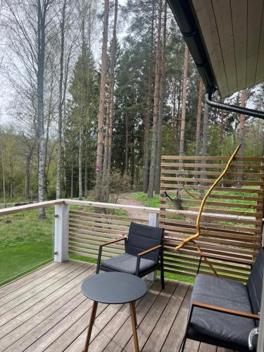 a porch with two chairs and a bench on a deck at Kiiski Home in Teijo