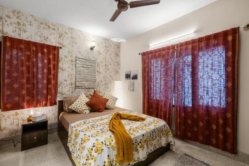 a bedroom with a bed and red curtains at Gaia Homes in Bangalore