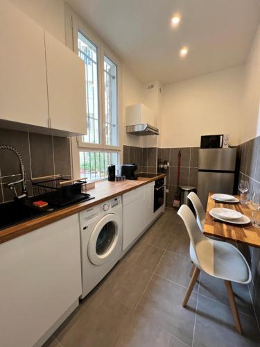 une cuisine avec un lave-linge et une table en bois dans l'établissement Appartement Nice proche centre-ville, à Nice