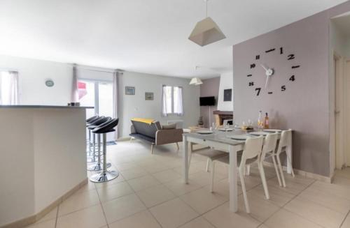 - un salon avec une table et une horloge murale dans l'établissement Appartement Agate Vals les bains, à Vals-les-Bains