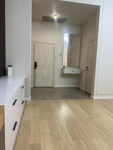 an empty room with a kitchen with wooden floors at ULY DALA Hotel in Saryaghash