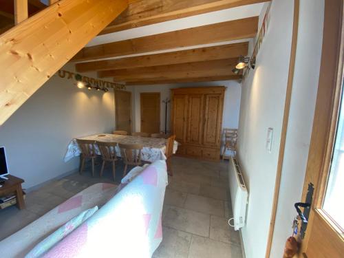 une chambre mansardée avec une table et des chaises dans une maison dans l'établissement Maison familiale Drôme - Ardèche, à Châteauneuf-du-Rhône