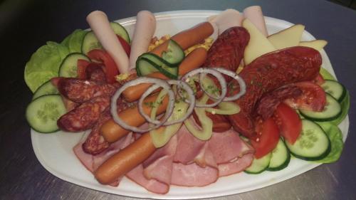 einen Teller Essen mit Wurst und Gemüse drauf in der Unterkunft Bocskai Domb Vendégház in Nagykálló