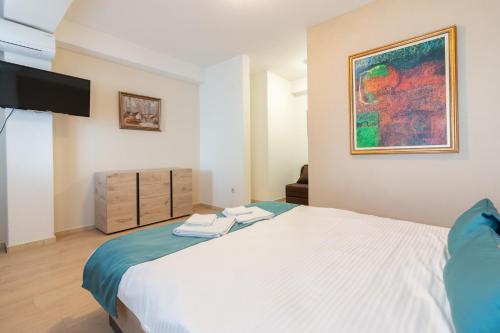 a bedroom with a bed and a painting on the wall at Konaci Manastir Sveti Stefan - Ohrid in Ohrid
