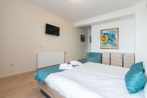 a bedroom with a bed and a tv on the wall at Konaci Manastir Sveti Stefan - Ohrid in Ohrid