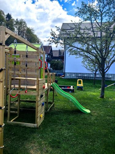 a wooden playground with a slide in a yard at Voinescu House - Natural Living & Eating in Şimon