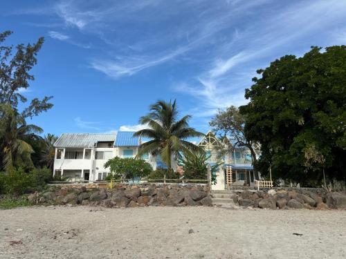 a house with a palm tree in front of a beach at BEACHFRONT - Les Fleurs Du Tamarin Residences in Tamarin