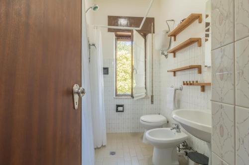 un bagno con un water, un lavandino e una finestra di Riva Verde a Bolsena