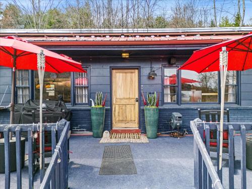 a blue house with a door and two red umbrellas at Green Acres Retreat in Hancock