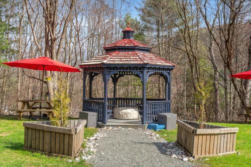 a gazebo in a park with a red umbrella at Green Acres Retreat in Hancock