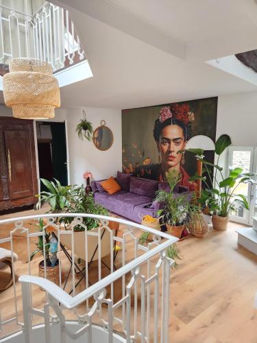 a living room with a couch and a painting on the wall at Charmante, maison de village, plage à proximité in Saint-Suliac
