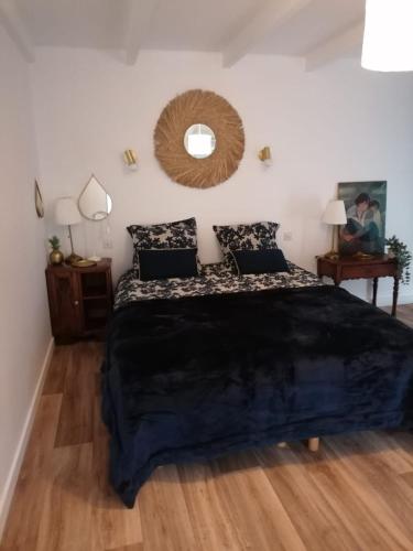 une chambre avec un grand lit et un miroir dans l'établissement Charmante, maison de village, plage à proximité, à Saint-Suliac