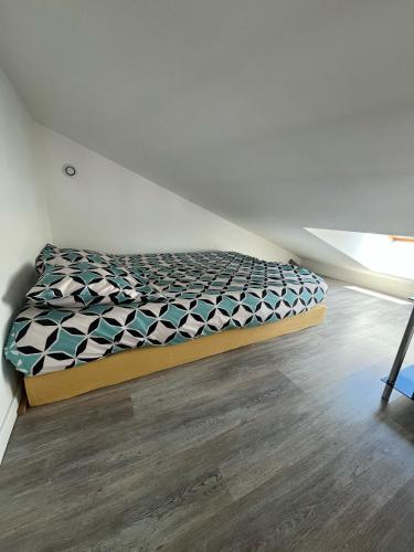 a bed in the corner of a room at Cathy et Eric in Beaurevoir