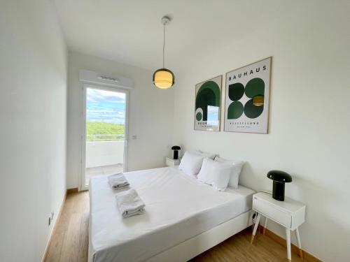 une chambre blanche avec un lit blanc et une fenêtre dans l'établissement PGH n42-Roof-Top avec Terrasse et Parking Prive, à La Grande Motte