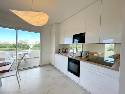 une cuisine avec des placards blancs et une salle à manger avec une table dans l'établissement PGH n42-Roof-Top avec Terrasse et Parking Prive, à La Grande Motte