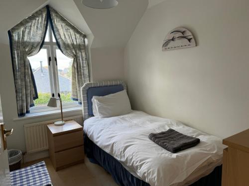 a small bedroom with a bed and a window at Anchor Cottage in Seaview