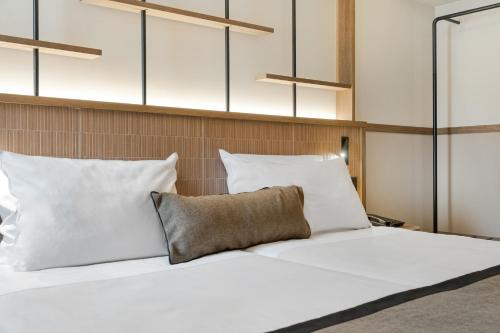 a bedroom with a white bed with white pillows at Capsis Astoria Heraklion in Heraklio Town