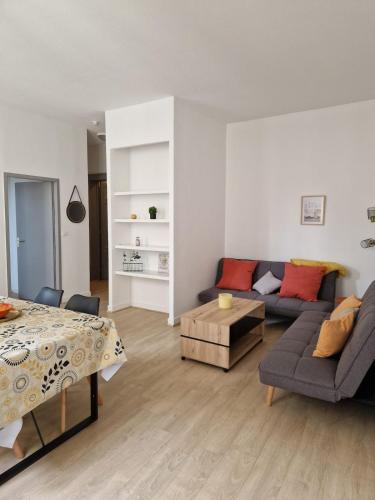 un salon avec un canapé et une table dans l'établissement Le Moulin hyper centre Libourne, à Libourne