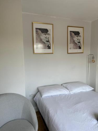 a bedroom with two beds and two pictures on the wall at Tulse Tavern in West Dulwich