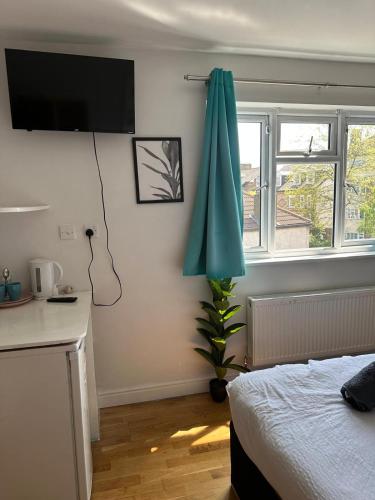 a bedroom with a bed and a green umbrella at Tulse Tavern in West Dulwich